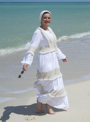 "Model wearing a Adorned Bohemian White Maxi Dress on the beach"