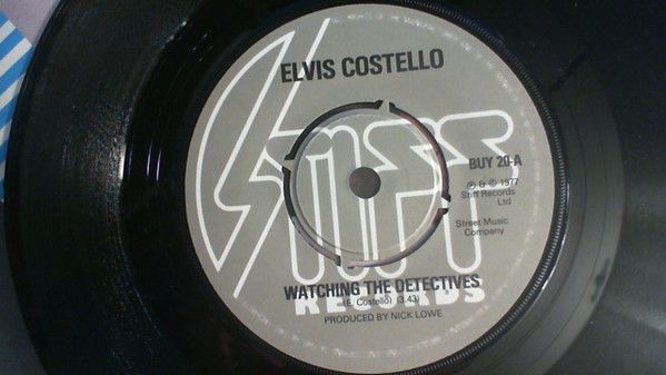 Elvis Costello - Watching The Detectives (7", Single, dar) (Very Good (VG))