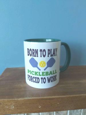 Pickleball mug with humourous theme and the wording &#39;Born to Play Pickleball, Forced to work&#39;