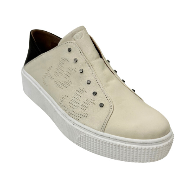 Angled front view of an Italian leather sneaker in a creamy white color with black heel and white sole.  No laces - tiny metal buttons on the sides 