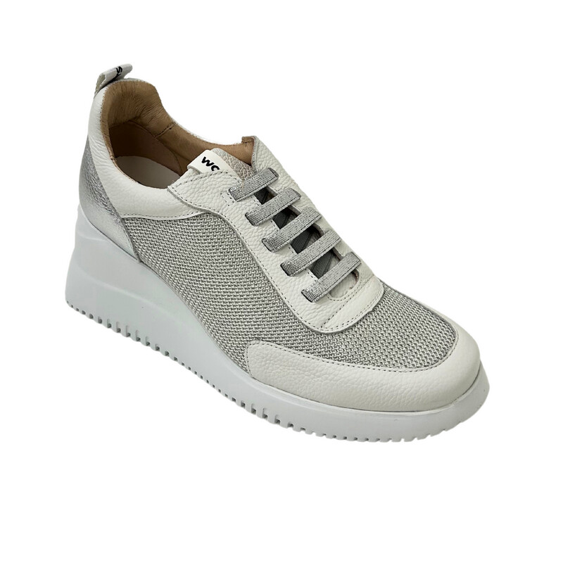 Angled front view of a wedge sneaker style shoe.  White leather and textile combo.