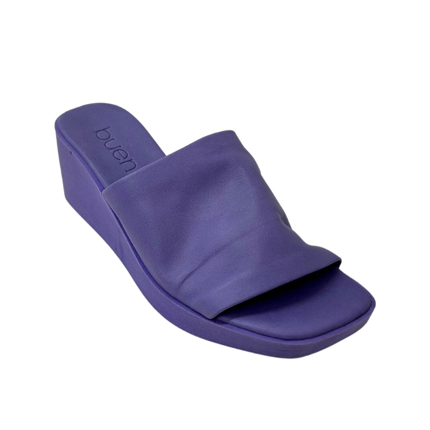 Angled side view of a pair of lavender colored mules with a wedge heel