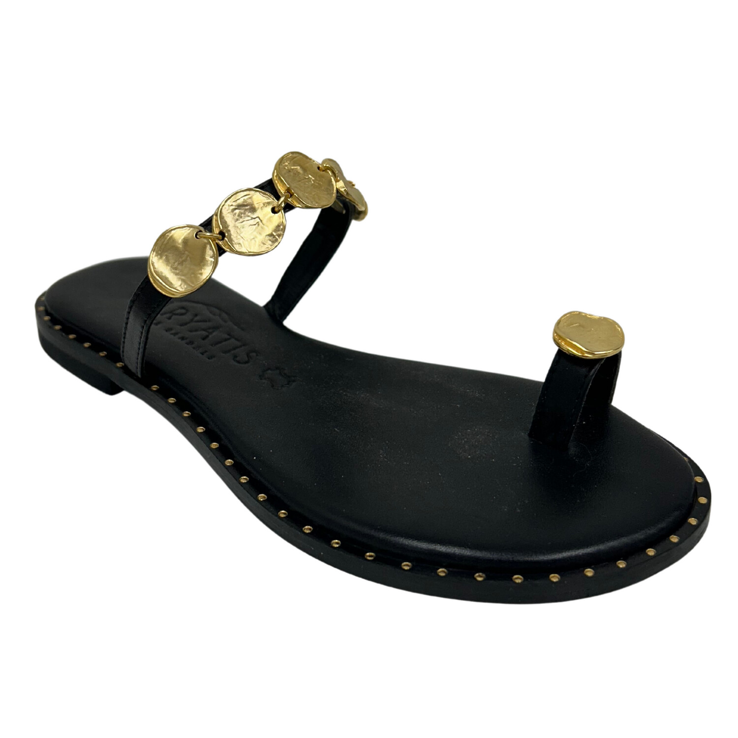 Angled front view of a simple, black leather sandal.  Toe loop in front and one thin strap across top of foot.  Both feature circular gold discs.  Gold pins across outsole