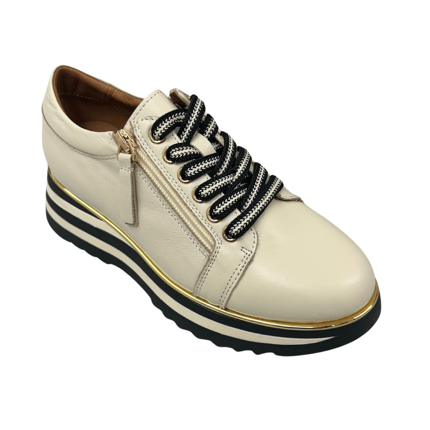 Angled front view of a wedge sneaker in a cream leather.  Laces in front with a side zipper for easy on/off.