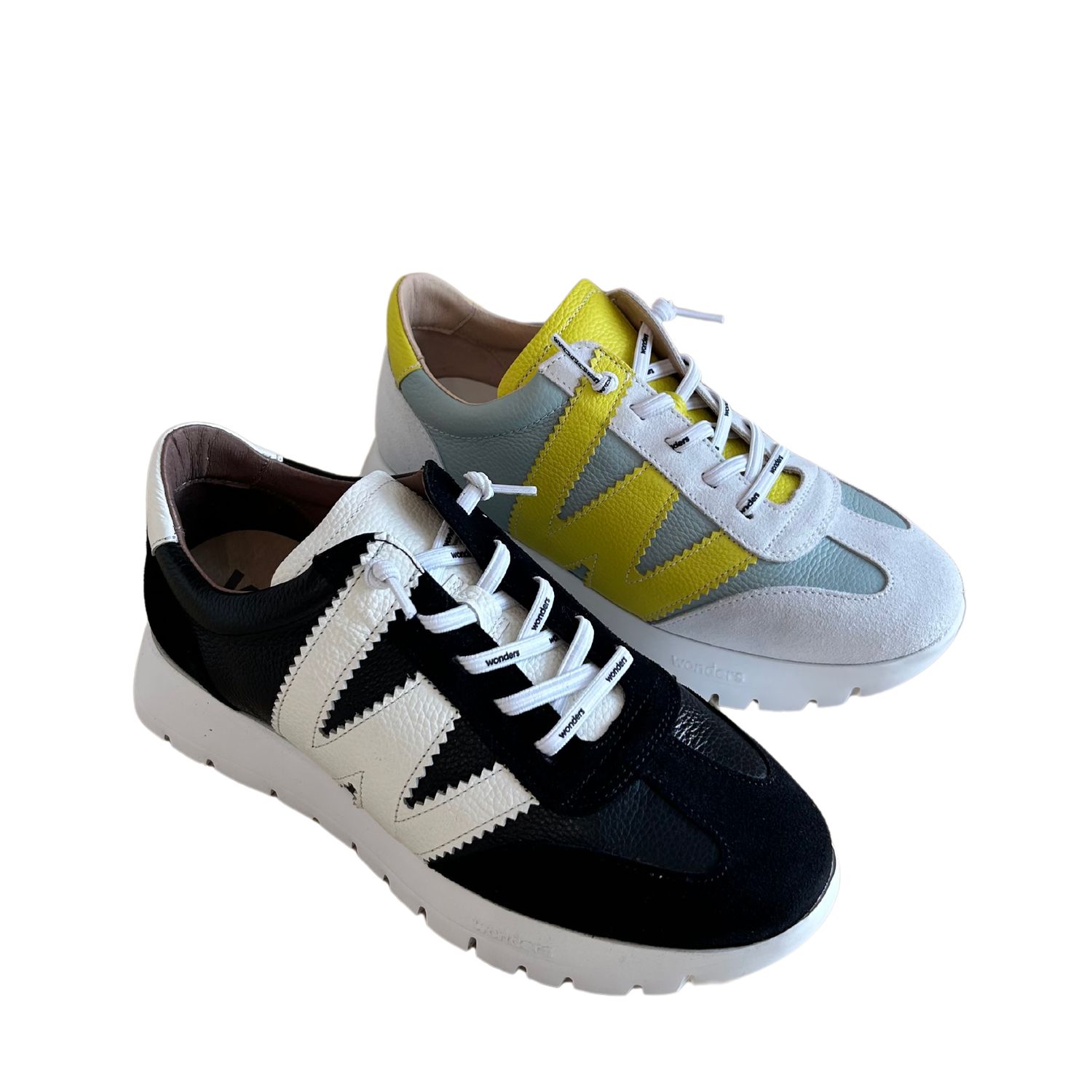 Angled front view of leather sneakers shown in black and an aqua.