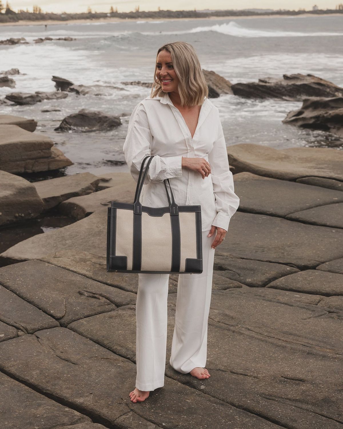 A woman holding a canvas tote bag.  Shop Louenhide