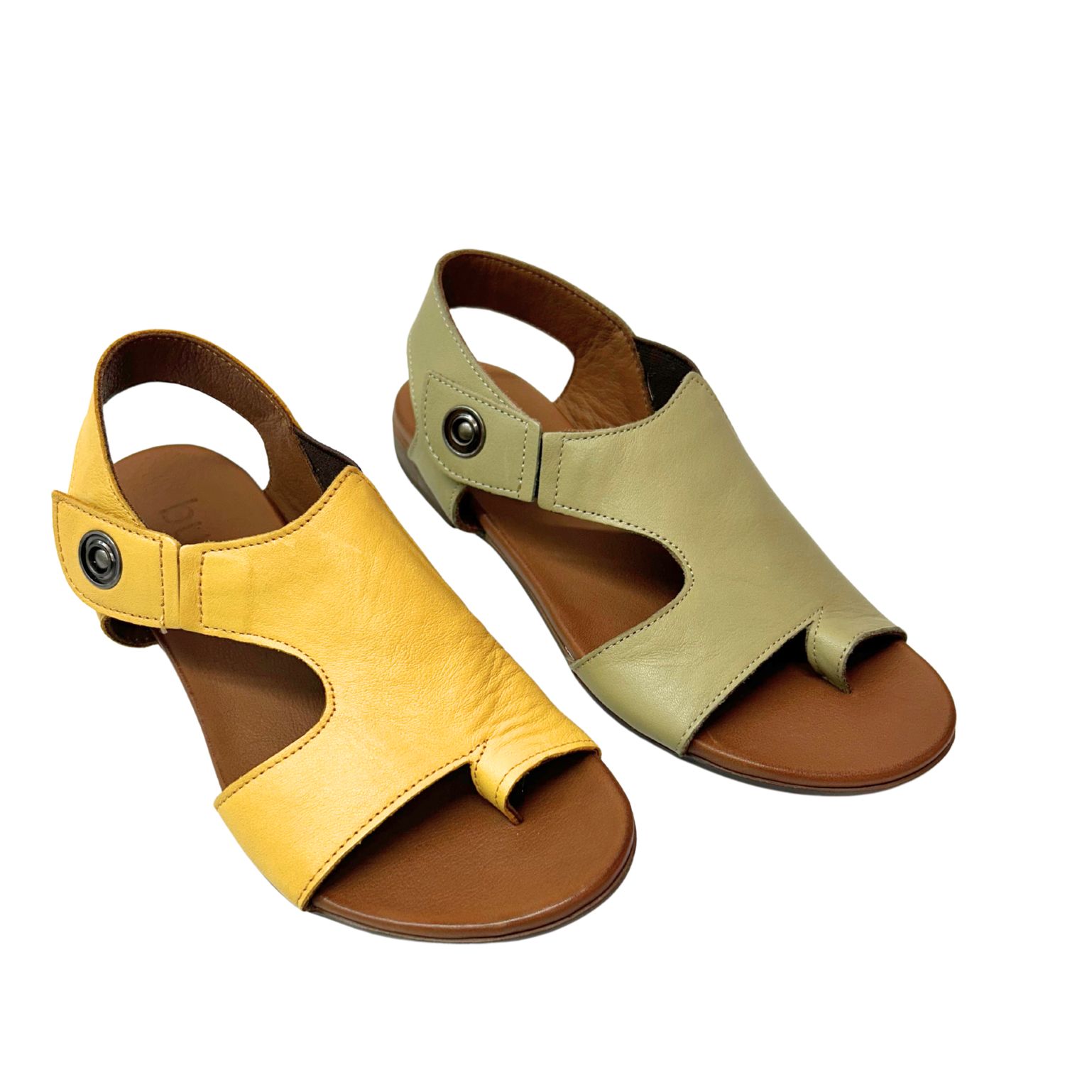 Angled front view of a flat sandal in a yellow and khaki leather.