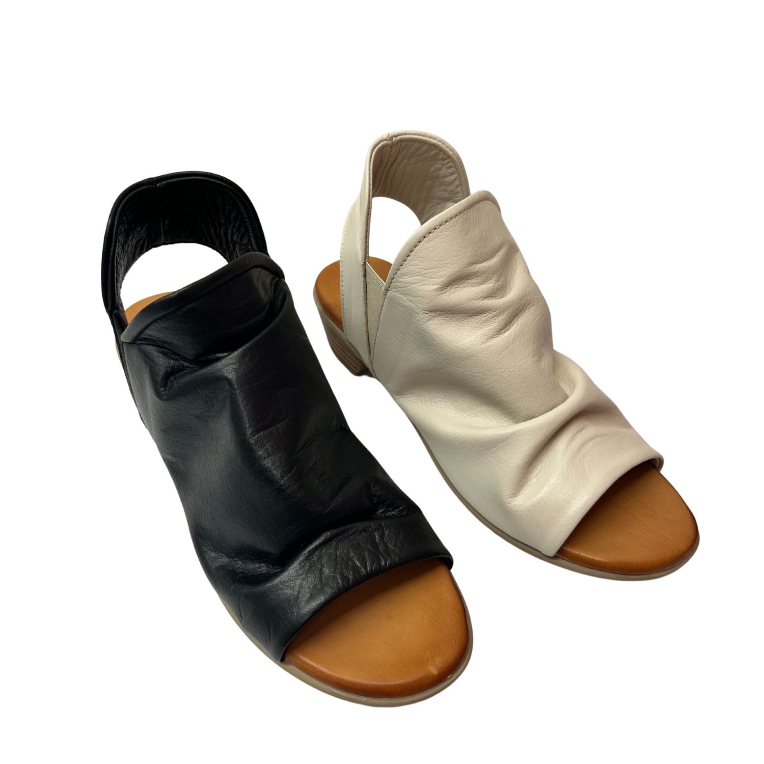 Angled front view of a shootie  (part shoe part boot).  Open toe and heel but full coverage upper.  Shown in both black and cream leather.
