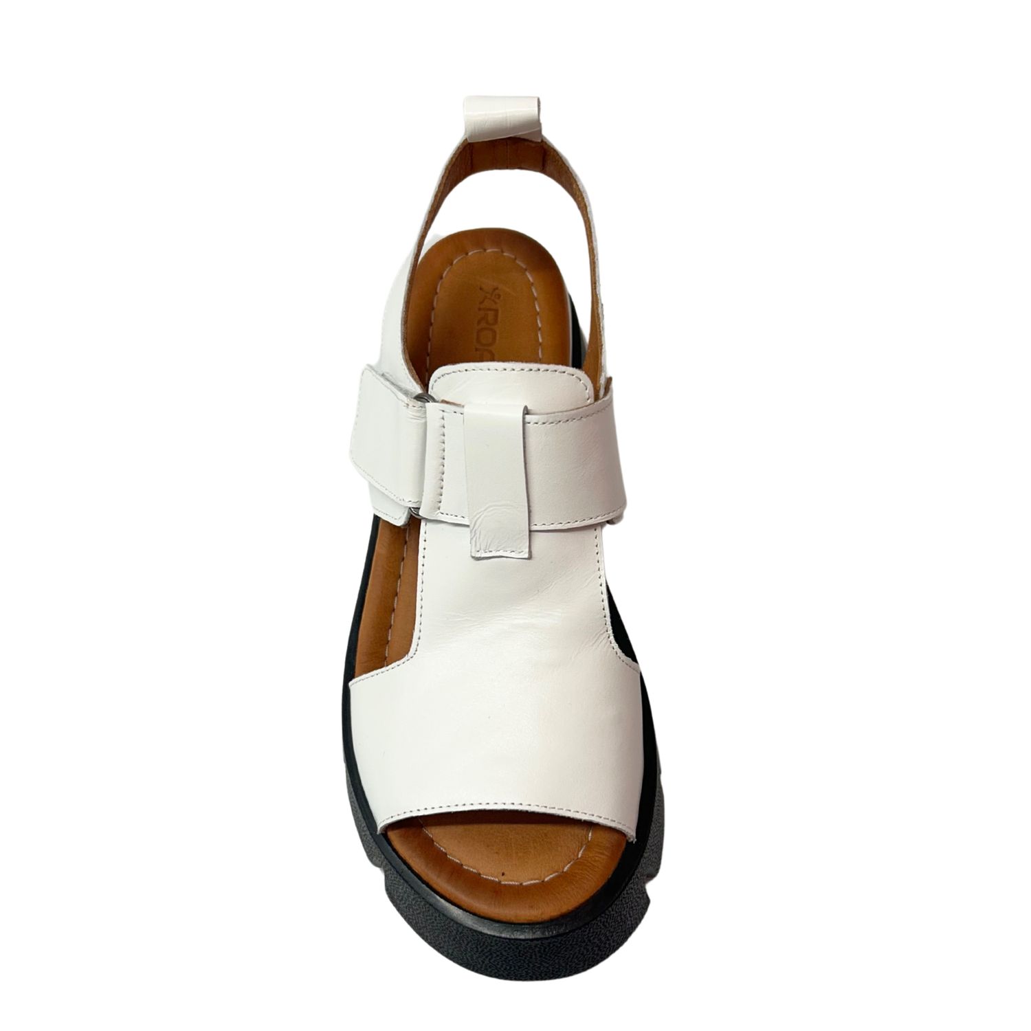 Top down view of a white leather sandal with a chunky black sole.
