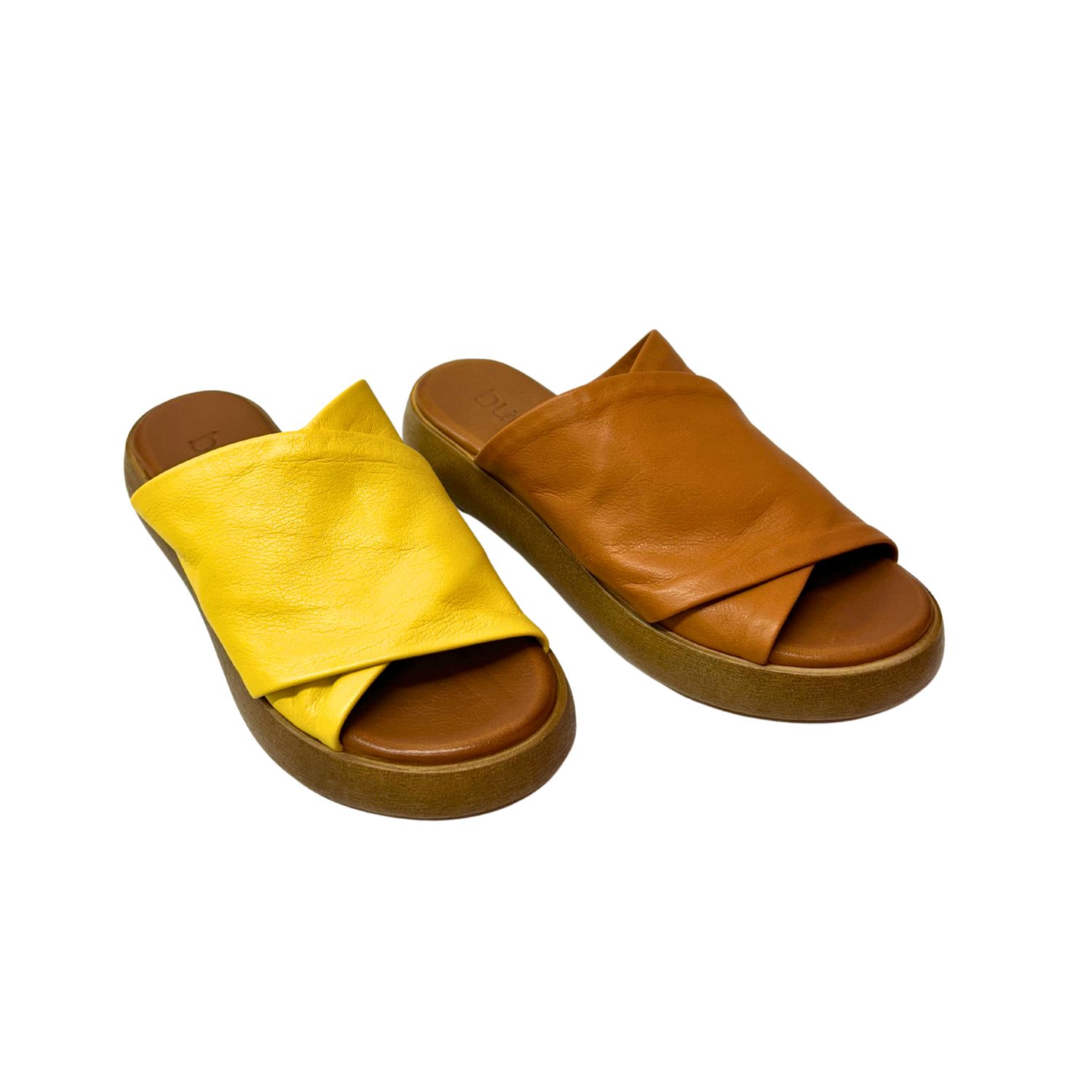 Angled front view of the Bueno Jaxon slide.  Open toe and heel.  Super soft leather covers a large portion of the foot.  Shown in both yellow and tan leather.