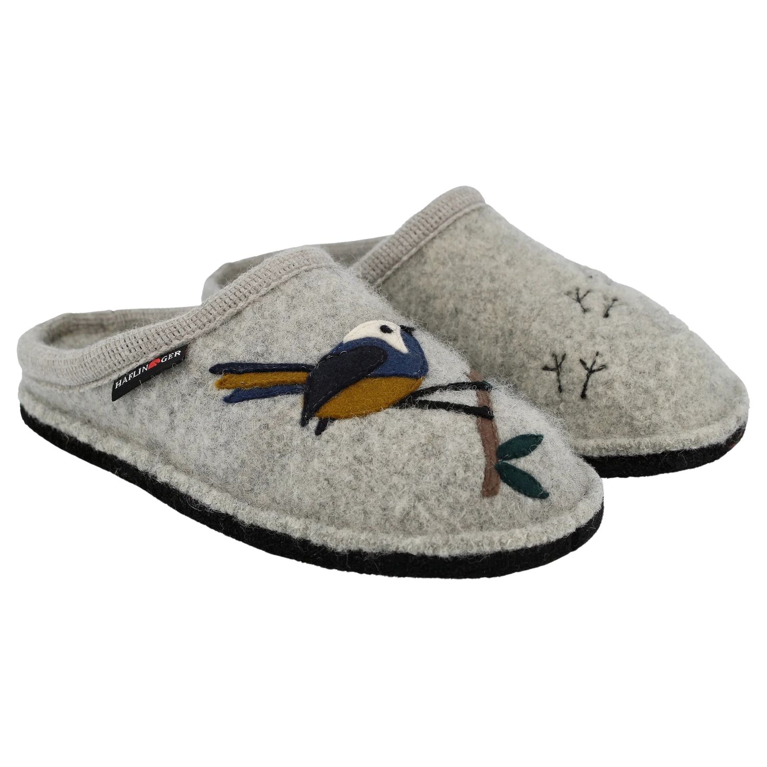 A pair of boiled wool slippers with a bird on the right one and little bird feet on the left.