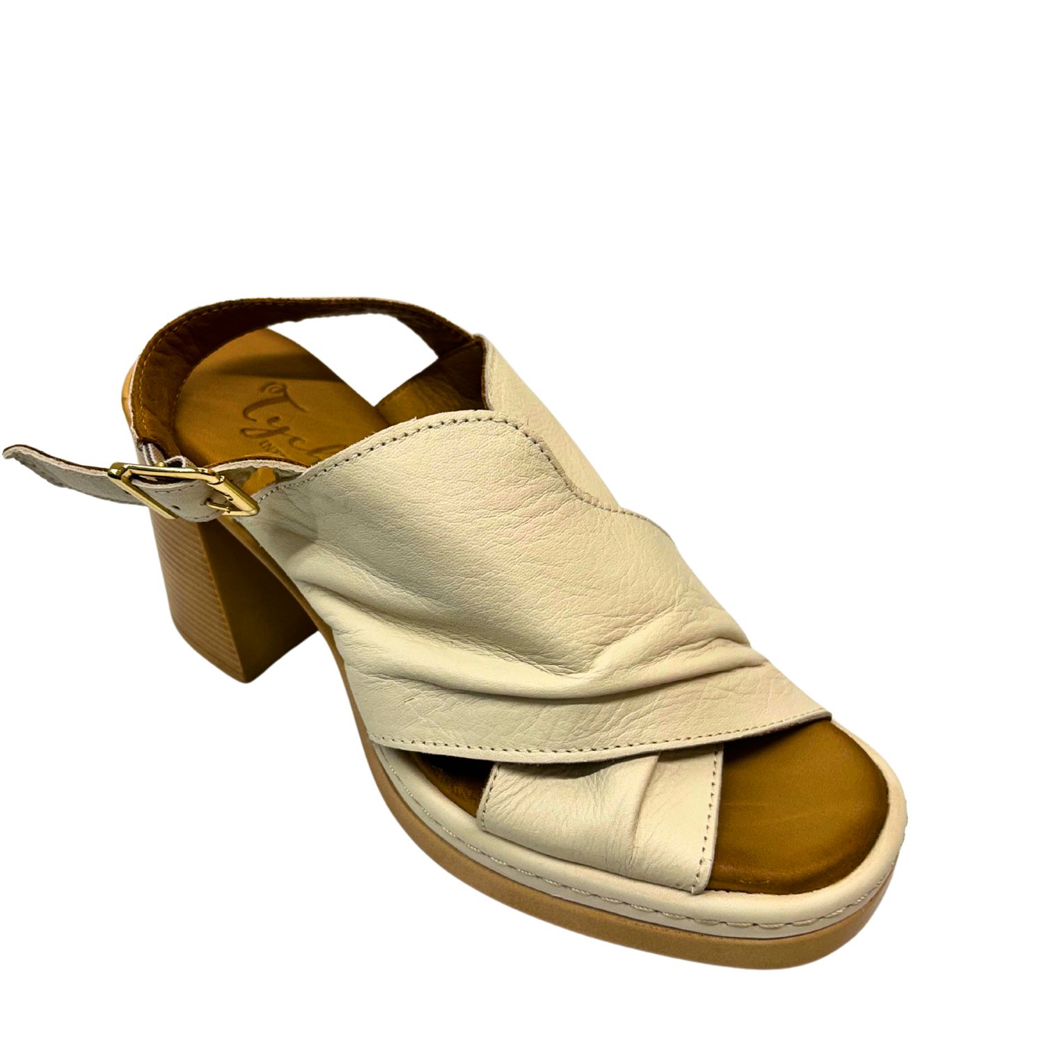 Angled front view of a platform sandal in a creamy white leather with a criss-cross over the top of foot.