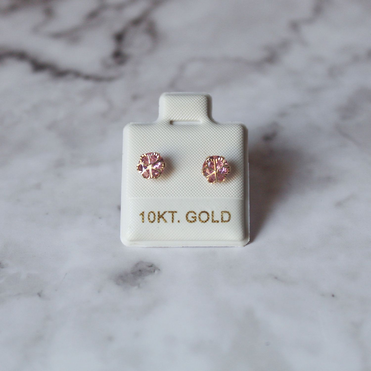 Arete broquel de flor con zirconia color rosada en oro 10KT