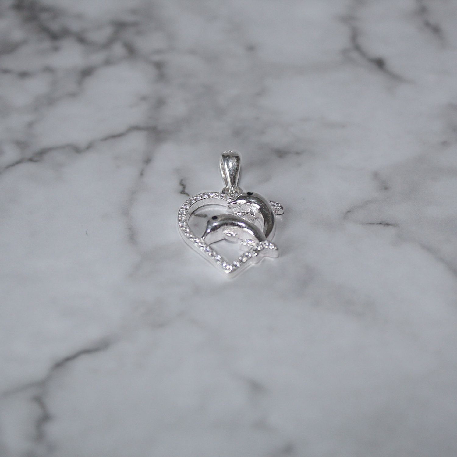 Dijes de corazón con dos delfines y zirconias