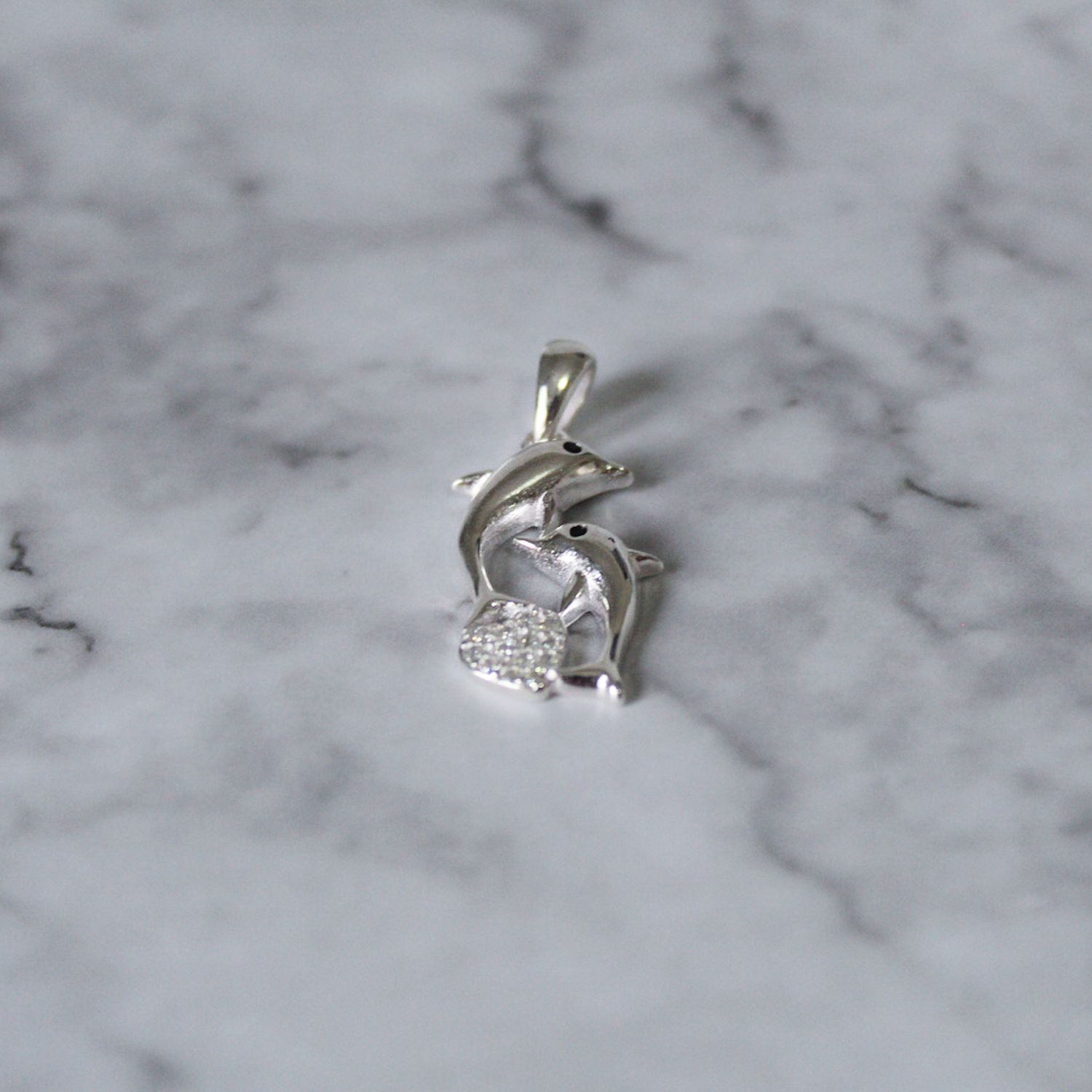 Dije dos delfines tu y yo con corazón de zirconia