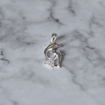 Dije dos delfines tu y yo con corazón de zirconia