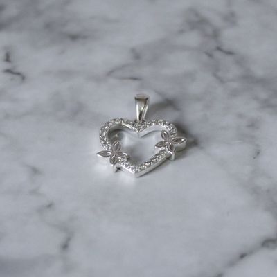 Dije corazón silueta con zirconia y detalle de flores