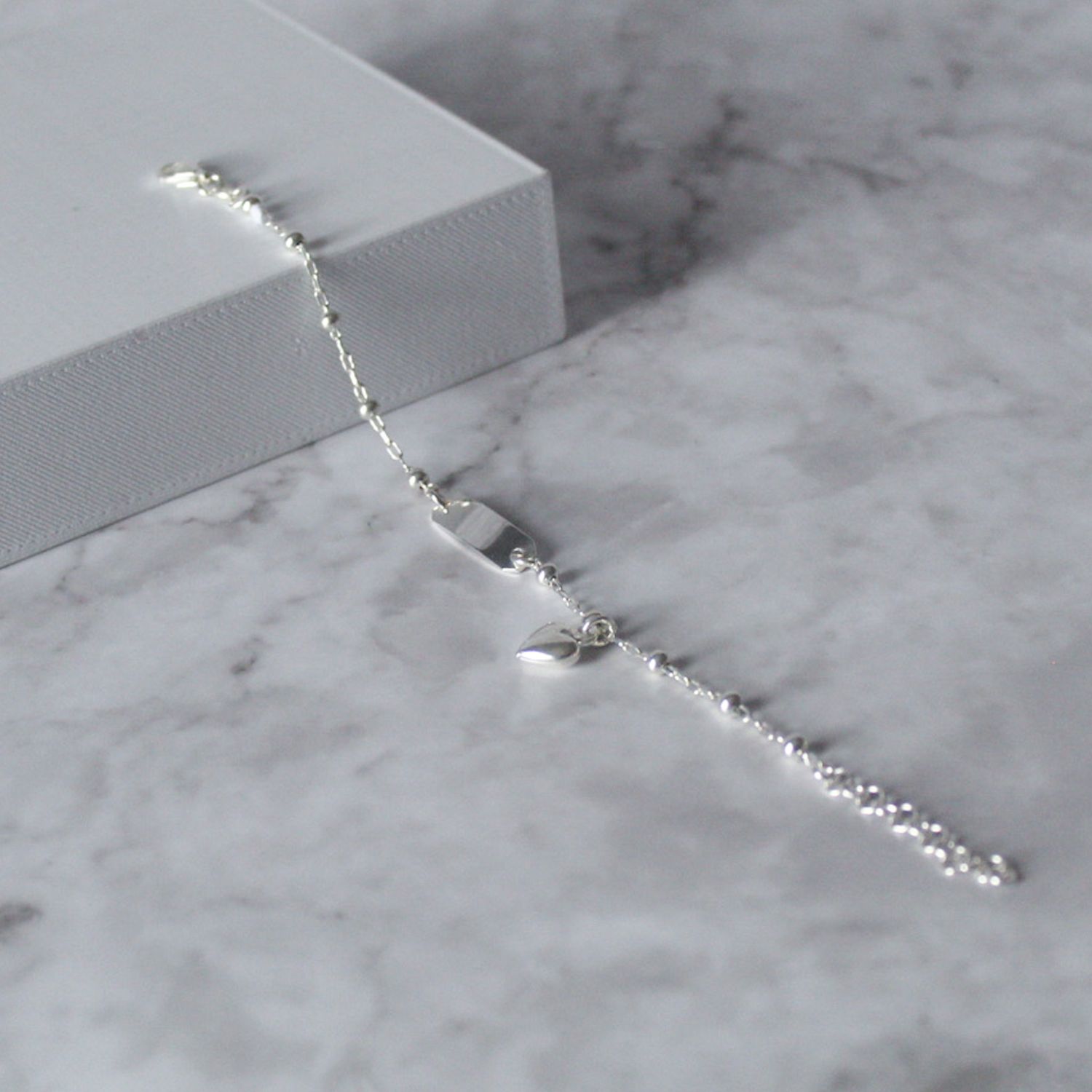 Pulsera con plancha, bolitas y dije de corazón colgante