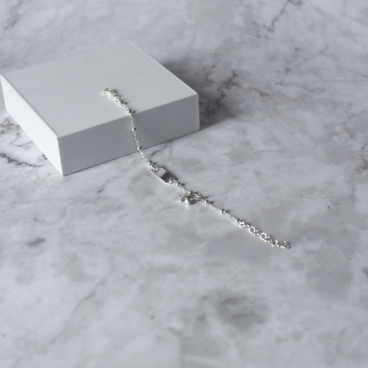 Pulsera con plancha, bolitas y dije de estrella colgante