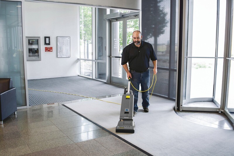 Kärcher Sensor XP 12 professional upright vacuum laying completely flat to sweep underneath a commercial hotel bed frame.