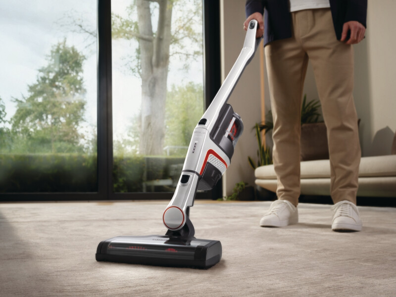 Miele Triflex HX1 Facelift cordless vacuum standing upright independently on a modern white kitchen tile floor.
