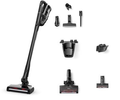 Electro Compact handheld motorized turbo brush removing pet hair from an upholstered armchair.