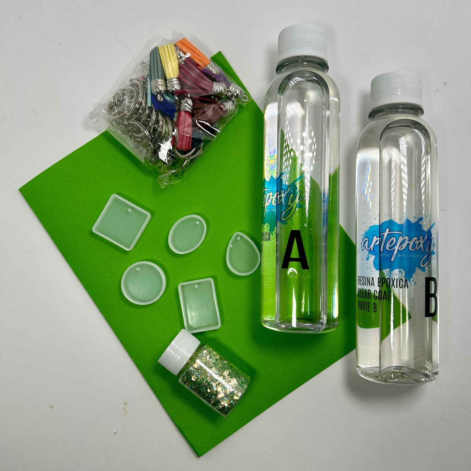 Molde 5 dijes
Resina 500ml.
Set de 20 borlas con cadenitas 
1 brillantina chunky o polvo de mica