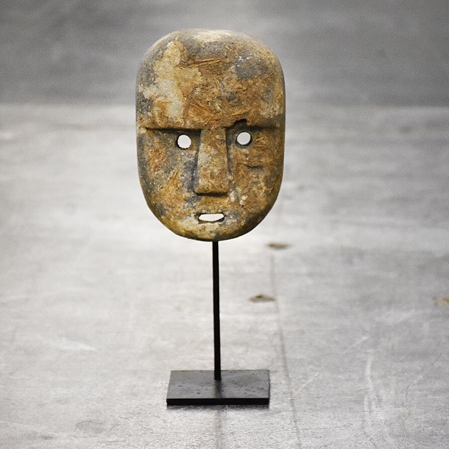 Stenen masker op voet
