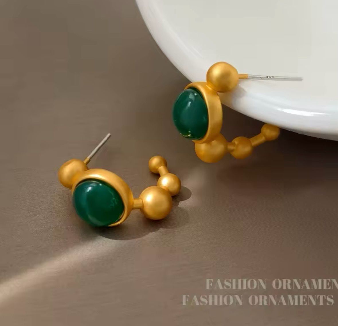Argollas doradas con piedra verde