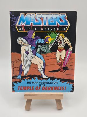 English cover of &#39;He-Man vs Skeletor in the Temple of Darkness&#39; vintage comic book from the Masters of the Universe series, highlighting the Sorceress being kidnapped by Skeletor and He-Man running after them. 