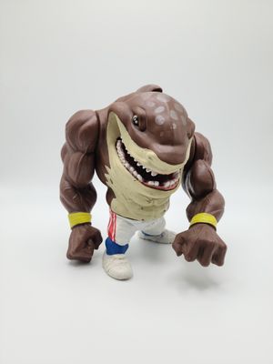Vue frontale de la figurine Big Slammu (bracelet jaune) Street Sharks de 1994 fabriquée par Mattel, debout sur une surface plane.