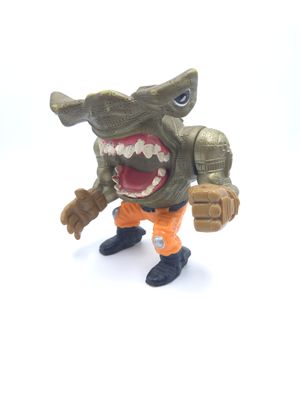 Vue de face de la figurine d&#39;action vintage Jet Pack Jab des Street Sharks de 1995 par Mattel. La figurine représente un requin-marteau avec un corps mécanique, portant un pantalon orange et des bottes noires, prêt à l&#39;action.