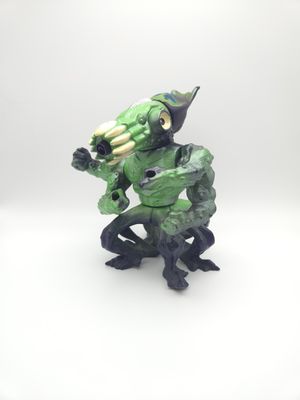 Vue de face de la figurine Killamari de la série Street Sharks, représentant une pieuvre aux grands yeux jaunes et à la peau verte et violette. La figurine est posée les bras levés, montrant ses mains griffues menaçantes.