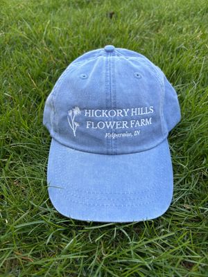 Blue hat with white logo sitting on grass.