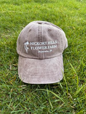 Brown hat with logo, sitting in grass