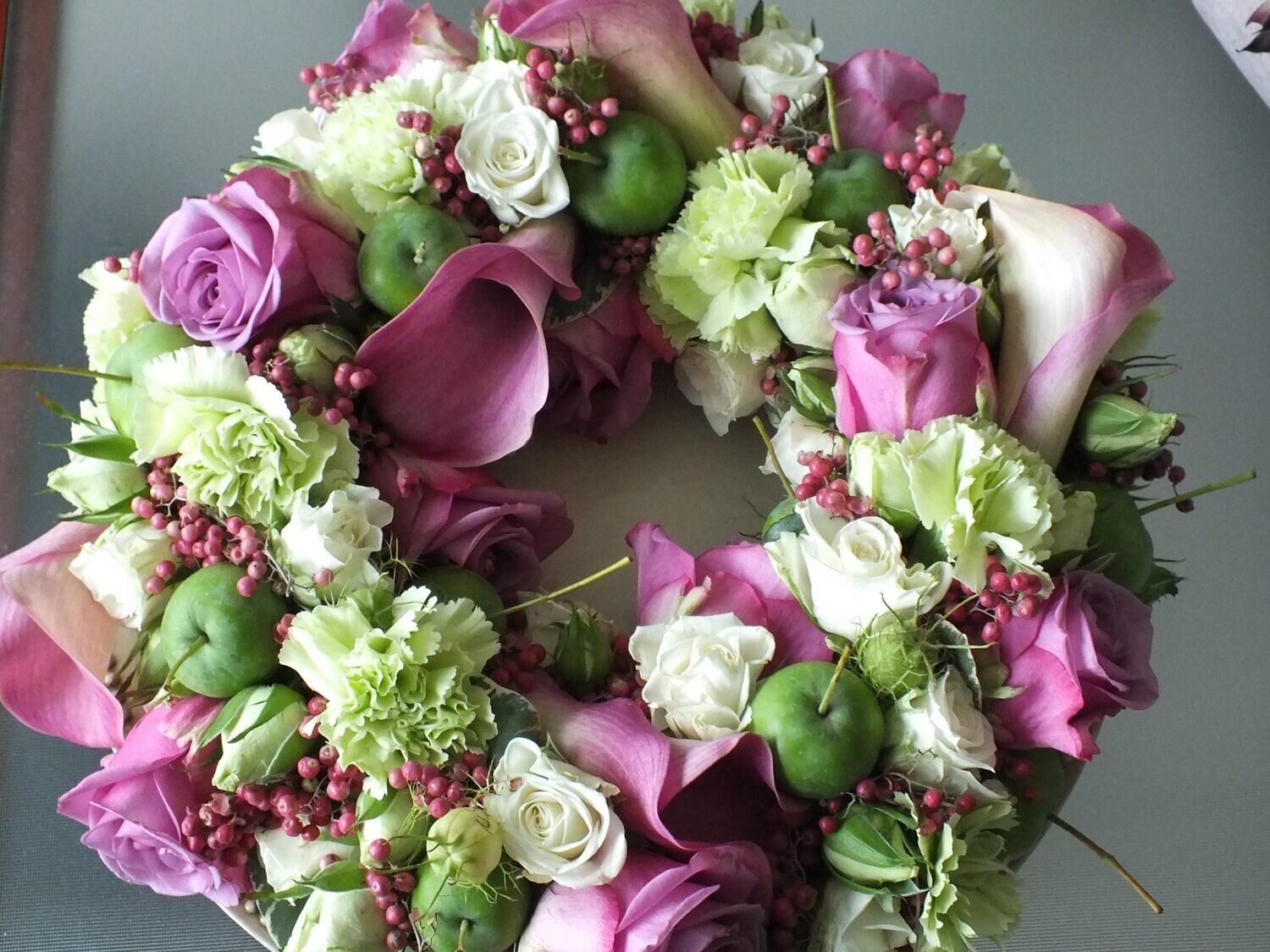 Krans 40cm opgevuld met Calla’s, Rozen, Anjers, peperbolletjes, appeltjes,.... Krans 40cm opgevuld met Calla’s, Rozen, Anjers, peperbolletjes, appeltjes,....