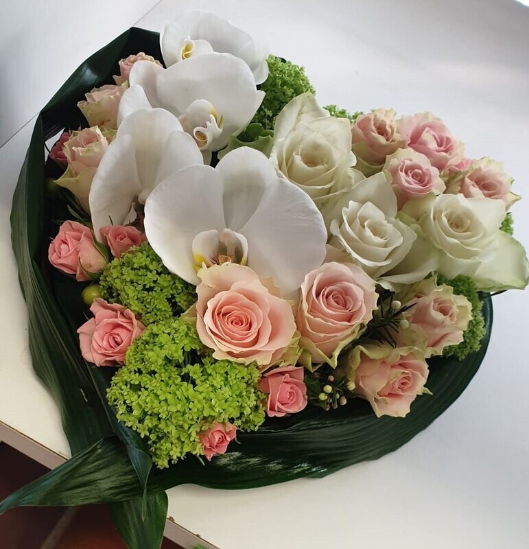 Hartvormig bloemstuk met Orchideeën, Rozen, Viburnum en afgewerkt met Aspidistrablad Hartvormig bloemstuk met Orchideeën, Rozen, Viburnum en afgewerkt met Aspidistrablad