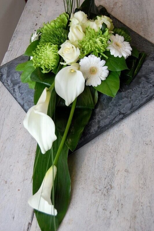 Grafstuk langwerpig op schotel met Calla's, Chrysanten, Germini's en Roosjes Grafstuk langwerpig op schotel met Calla's, Chrysanten, Germini's en Roosjes