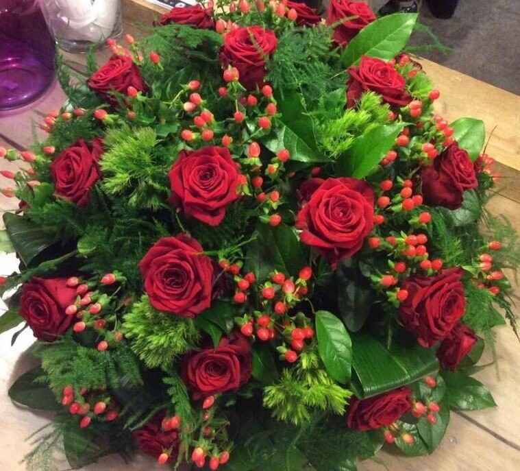 Rond bloemstuk met Rozen, Greentrick, Aspidistrablad en Hybericum Rond bloemstuk met Rozen, Greentrick, Aspidistrablad en Hybericum