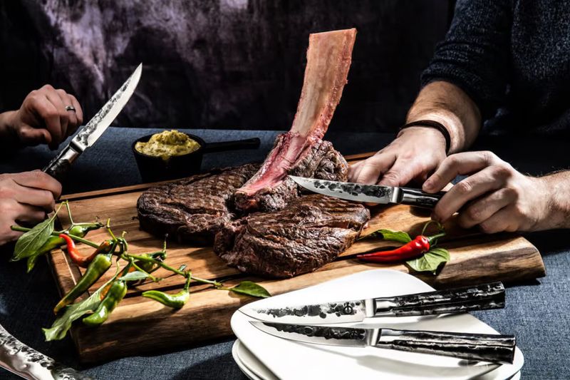 Forged Intense steakmessen set in gebruik steak snijden aan BBQ tafel