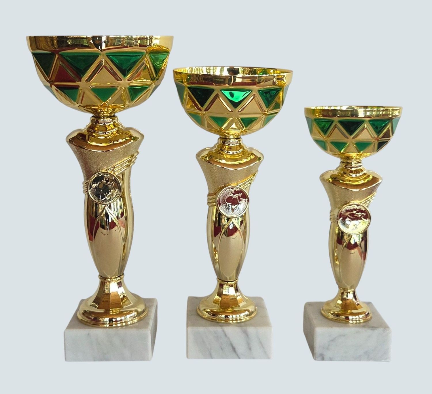 Drei Pokale der Serie RHEA mit grün-goldfarbener Schale, goldfarbenem Pokalkörper mit Emblemhalter und Marmorsockel in unters