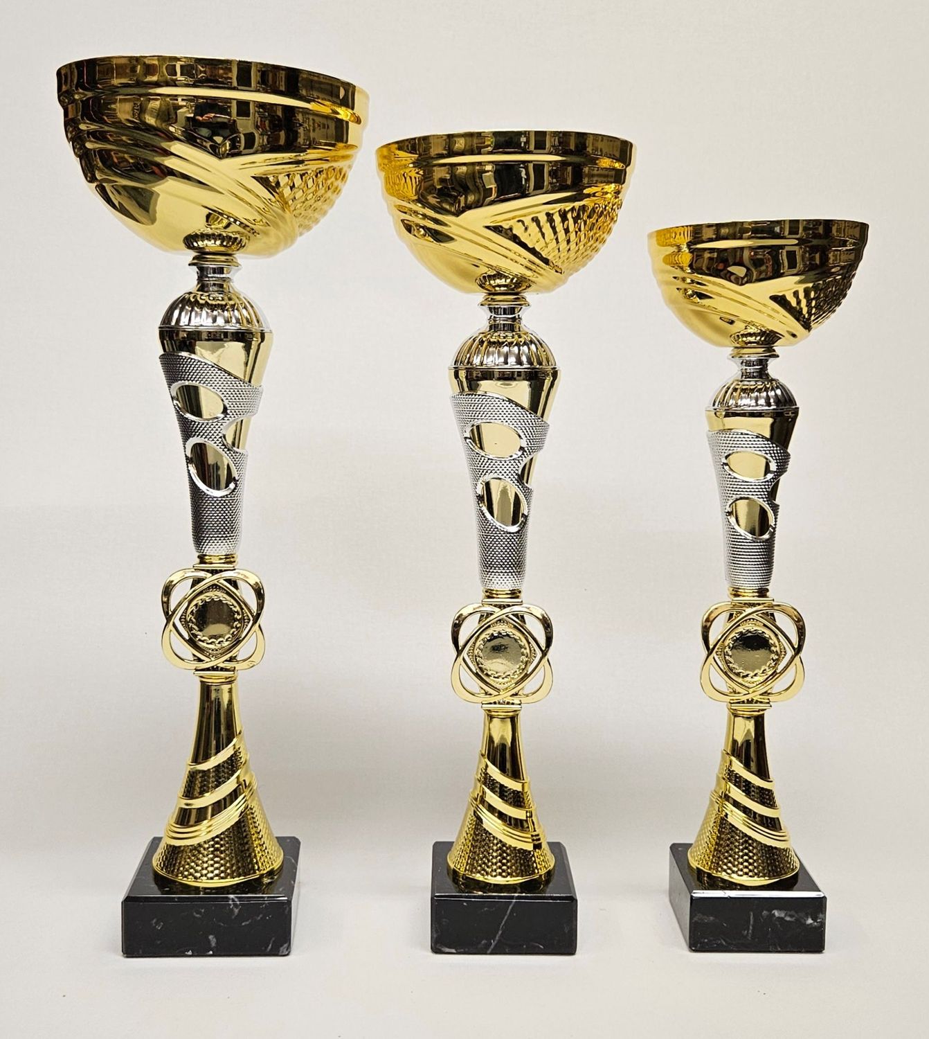 Pokal Pokal-Set „Lina 2.0“ in Gold mit silberfarbenem Ziermittelteil, strukturierter Schale und schwarzem Marmorsockel, drei Größen