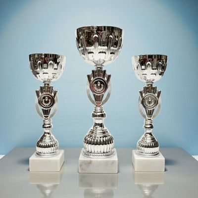 Pokal-Set „Alina“ in Silber mit klassischer Schale, Emblemhalter im Mittelteil und hellem Marmorsockel, drei Größen