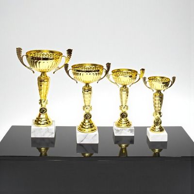 Pokal Pokal „Goldenstar“ im 4er-Set mit goldfarbenen Metallschalen mit Henkeln, klassischem Mittelteil mit Emblemträger und weißem