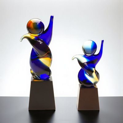 Glaskulptur Dancingstar mit abstrakter Tanzfigur aus Farbglas auf dunklem Holzsockel in zwei Größen