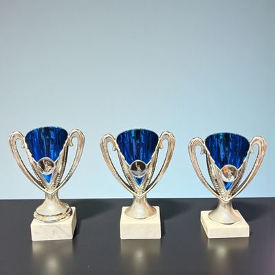 Kinderpokal Indigo mit blauer Schale, silberfarbenen Henkeln, Emblemträger und hellem Marmorsockel