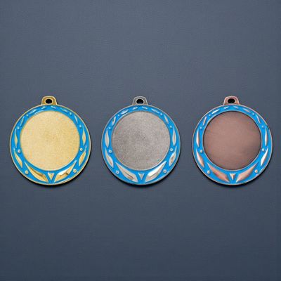 Großformatige Metallmedaille mit glatter Mittelfläche und umlaufendem blauem Farbkranz mit dekorativen Akzenten. Durchmesser 
