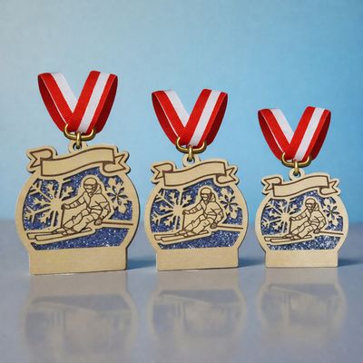 Holzmedaille HM-SKI-700 mit Ski-Motiv und Banner, naturbelassene Optik, in 10,5 / 9,0 / 7,5 cm blauer Glitzeracrylhintergrund