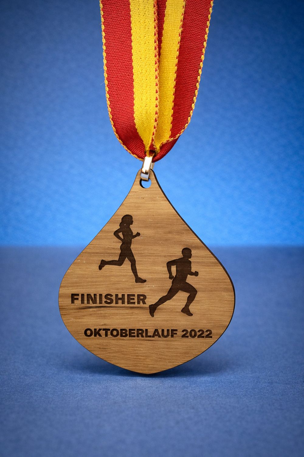 Holzmedaille in individueller Form aus naturbelassenem Holz mit Lasergravur und Medaillenband