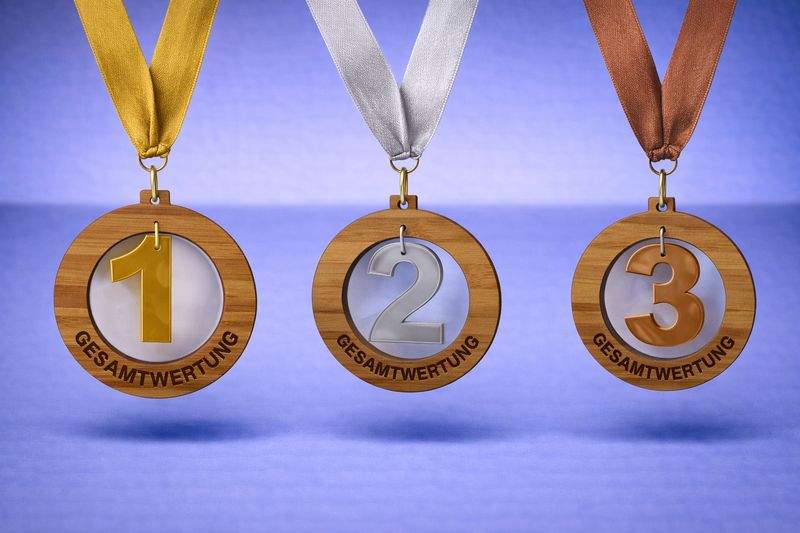 Ausgeschnittene Holzmedaille mit 1–2–3-Hänger aus Acryl. Der Gravurtext wird direkt im Holz individuell gestaltet